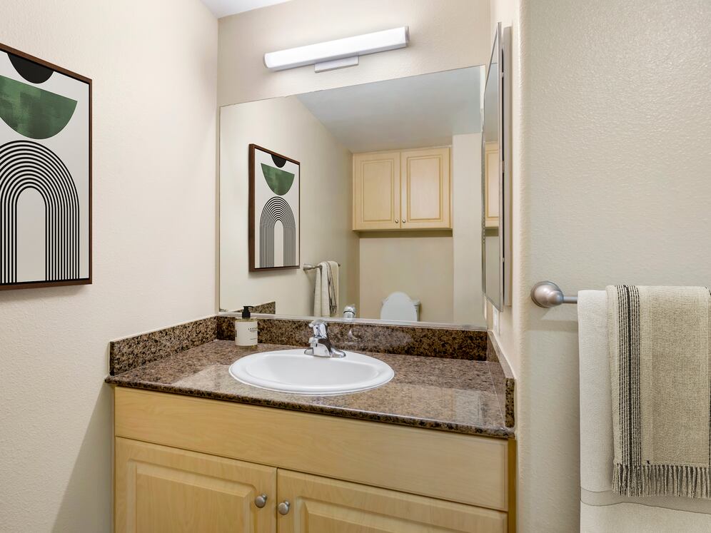 Classic Package II bath with brown speckled granite, oak cabinetry, and hard surface flooring