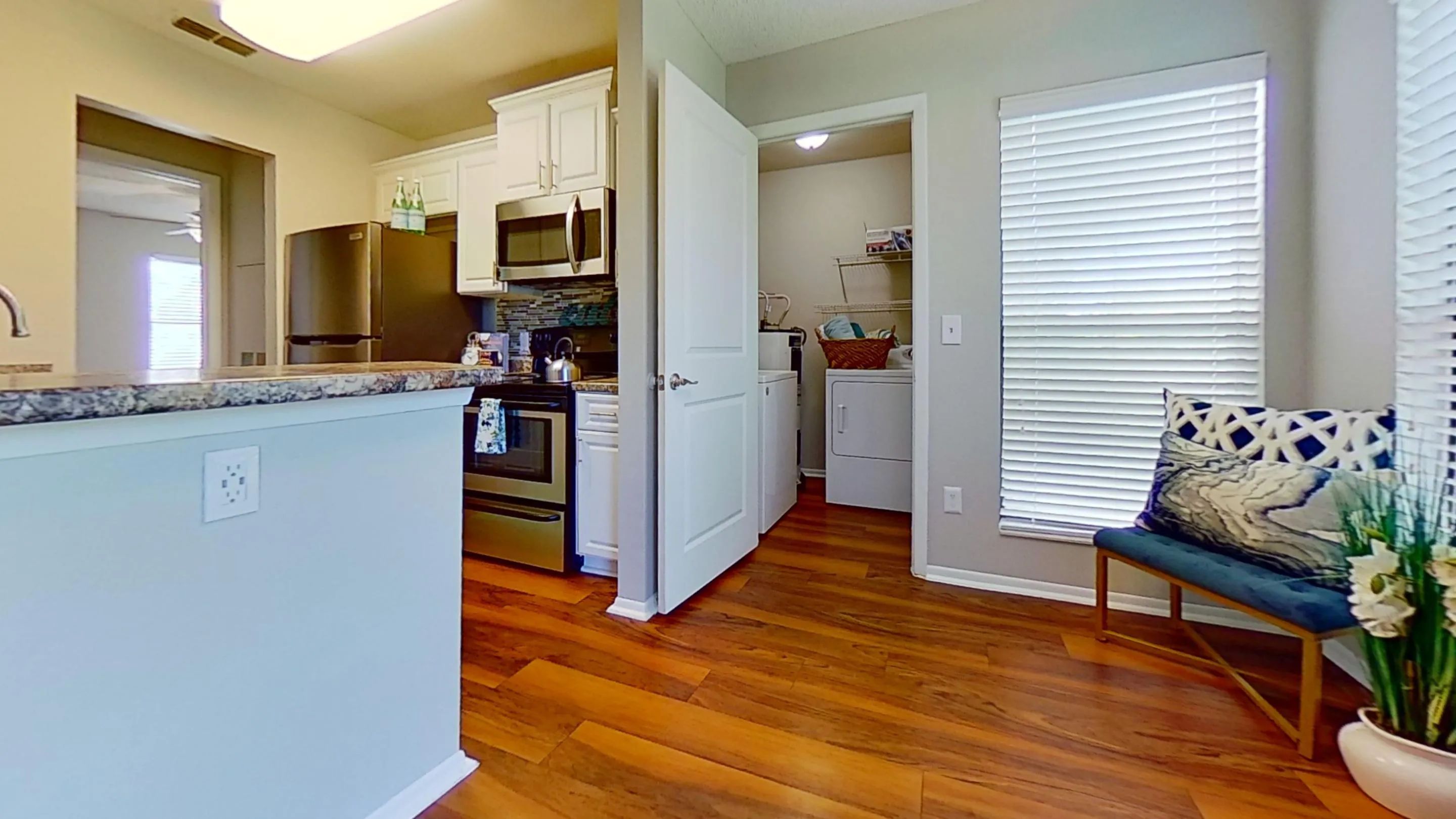 The Martinique Autograph floor plan showcases a modern kitchen with stainless steel appliances, adjacent to a convenient in-unit laundry room. Enjoy the blend of style and functionality in this beautiful space.