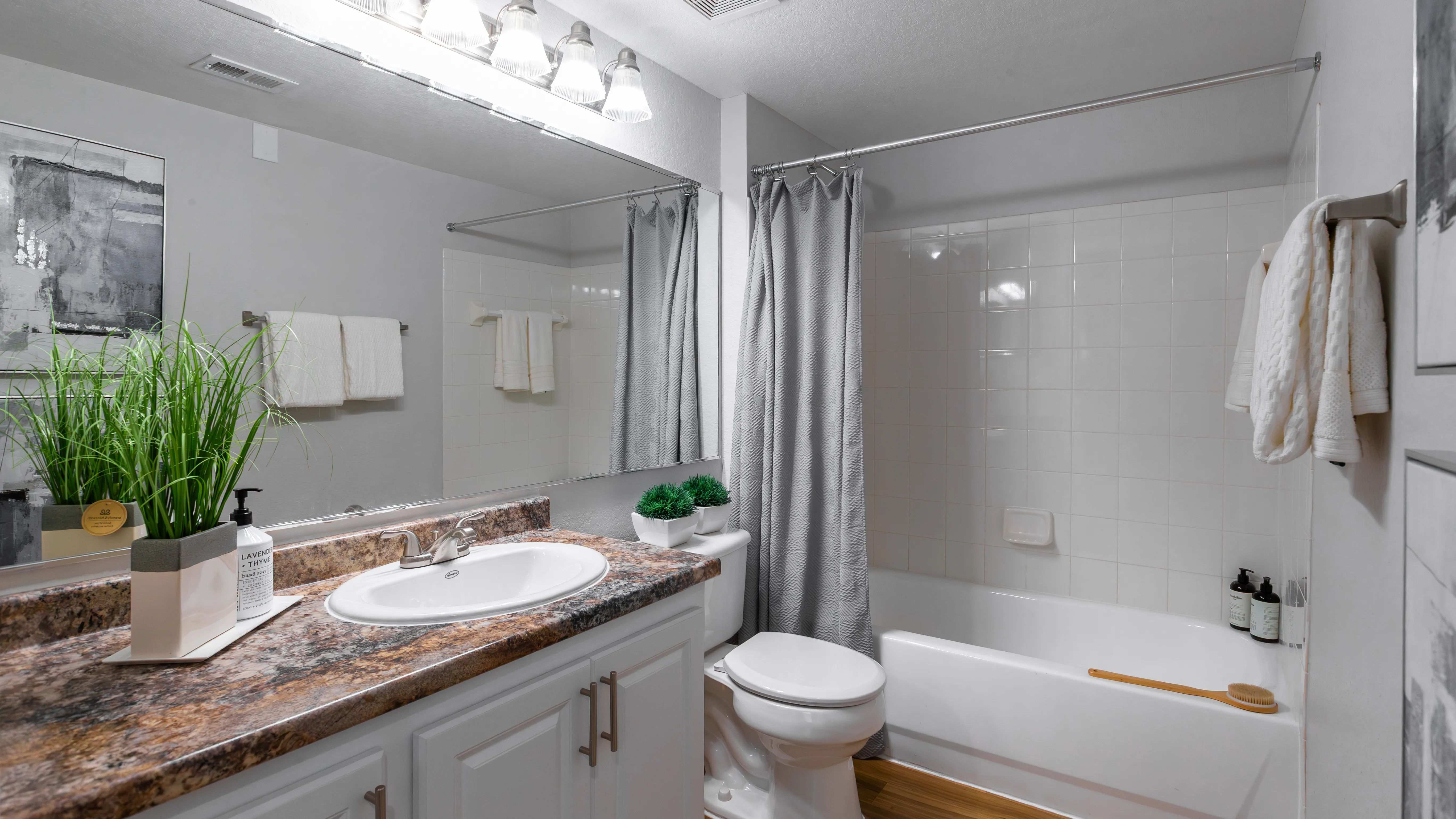 Refresh your routine in this stylish bathroom, complete with a full-size tub, granite-style countertops, and upgraded lighting.