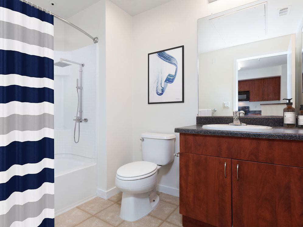 Classic Package I bath with grey laminate countertop, cherry cabinetry, and vinyl tile flooring