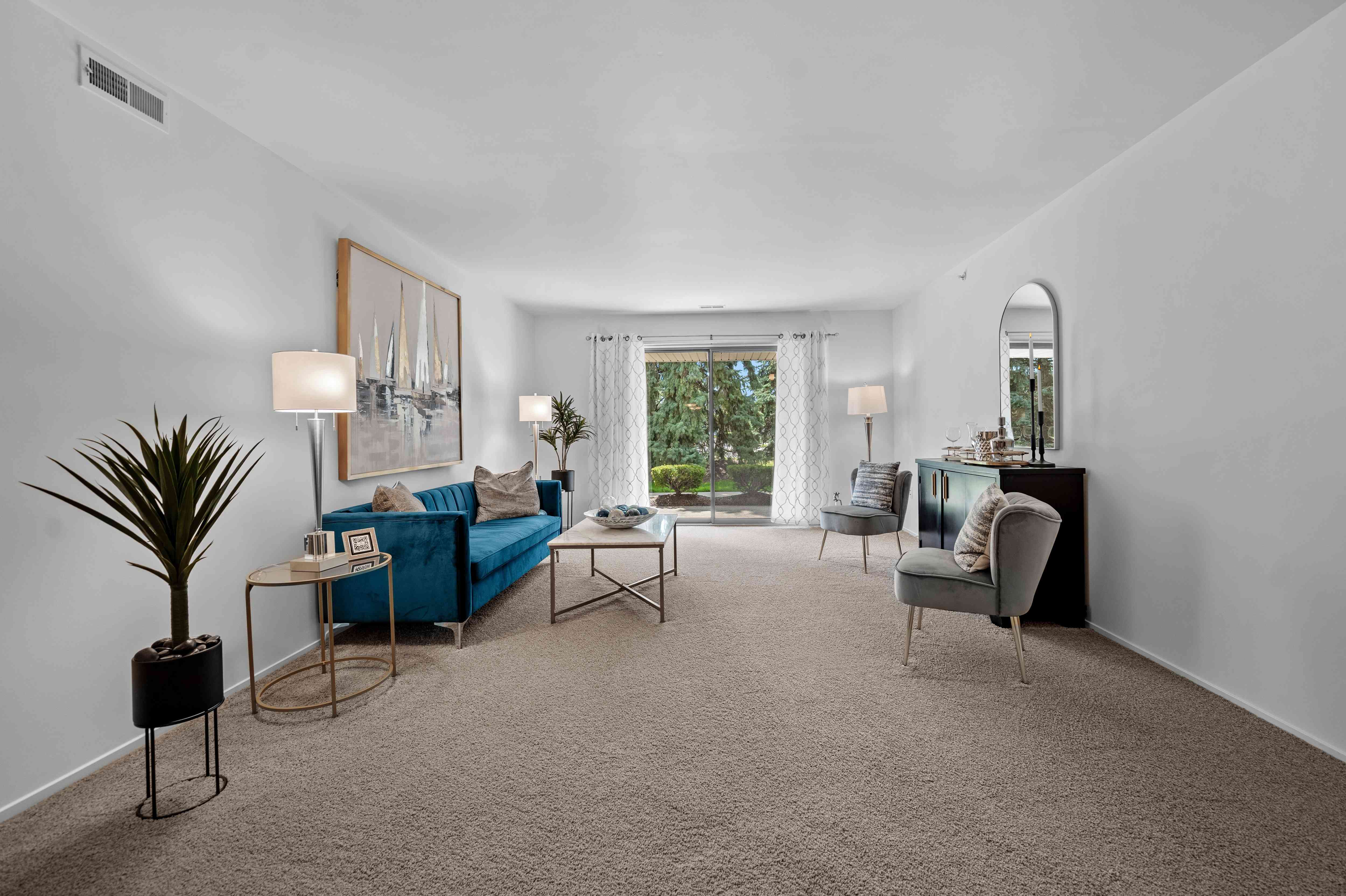 Spacious Living room with patio at Prentiss Pointe Apartments in Harrison Township