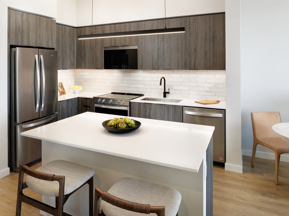Upgrade Collection II kitchen with espresso cabinetry, white tile backsplash, white quartz countertop, and hard-surface vinyl plank flooring