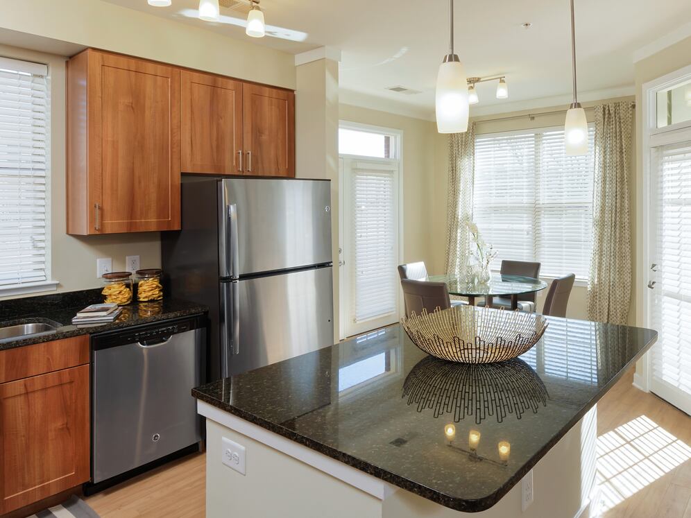 Classic Package I kitchen with stainless steel appliances, oak cabinetry, black granite countertops, and hard surface flooring