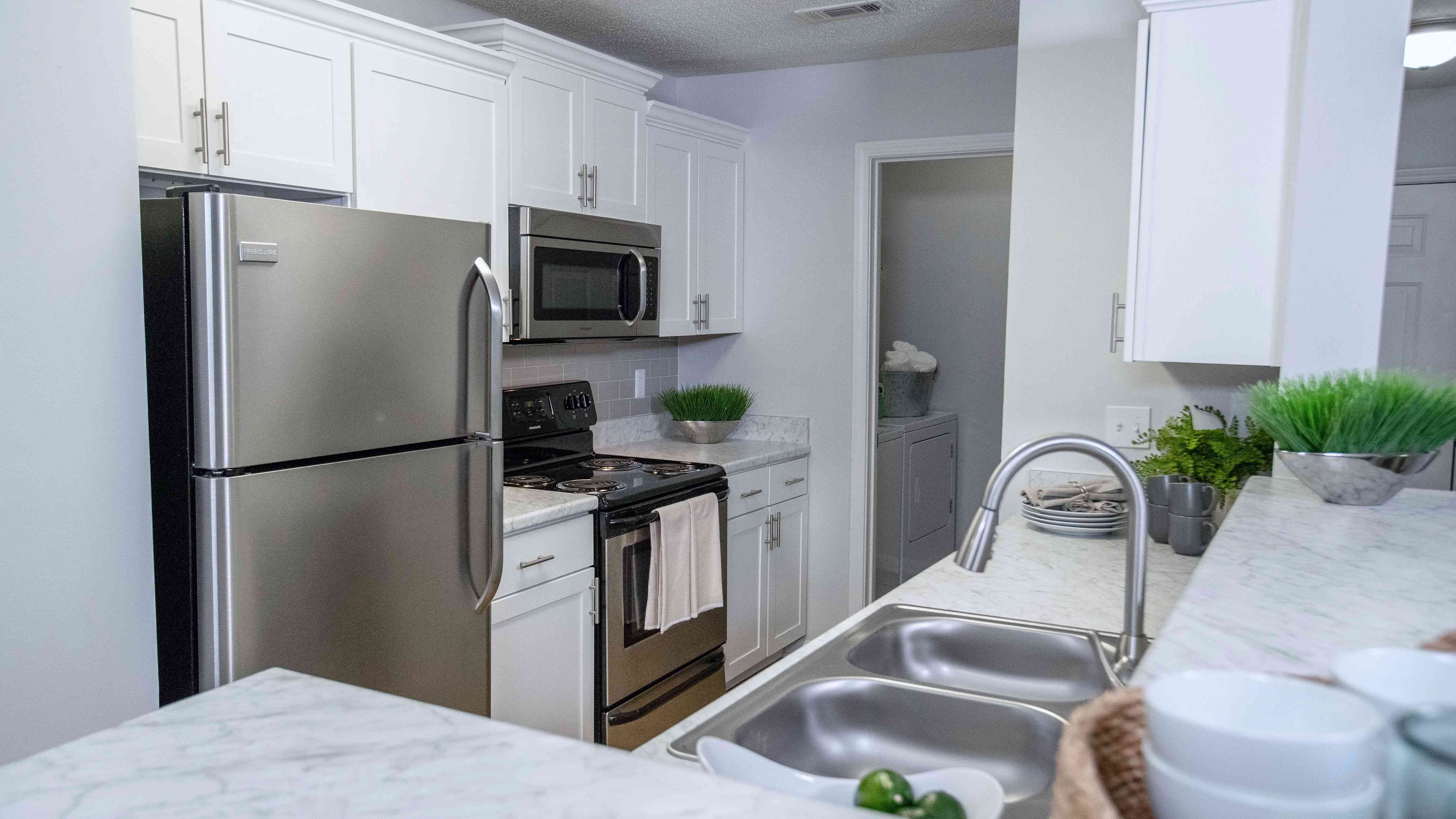 Carrara marble-inspired countertops grace the breakfast bar, creating a timeless and luxurious atmosphere in this expansive kitchen.  Ample countertop space and storage ensure both style and functionality.