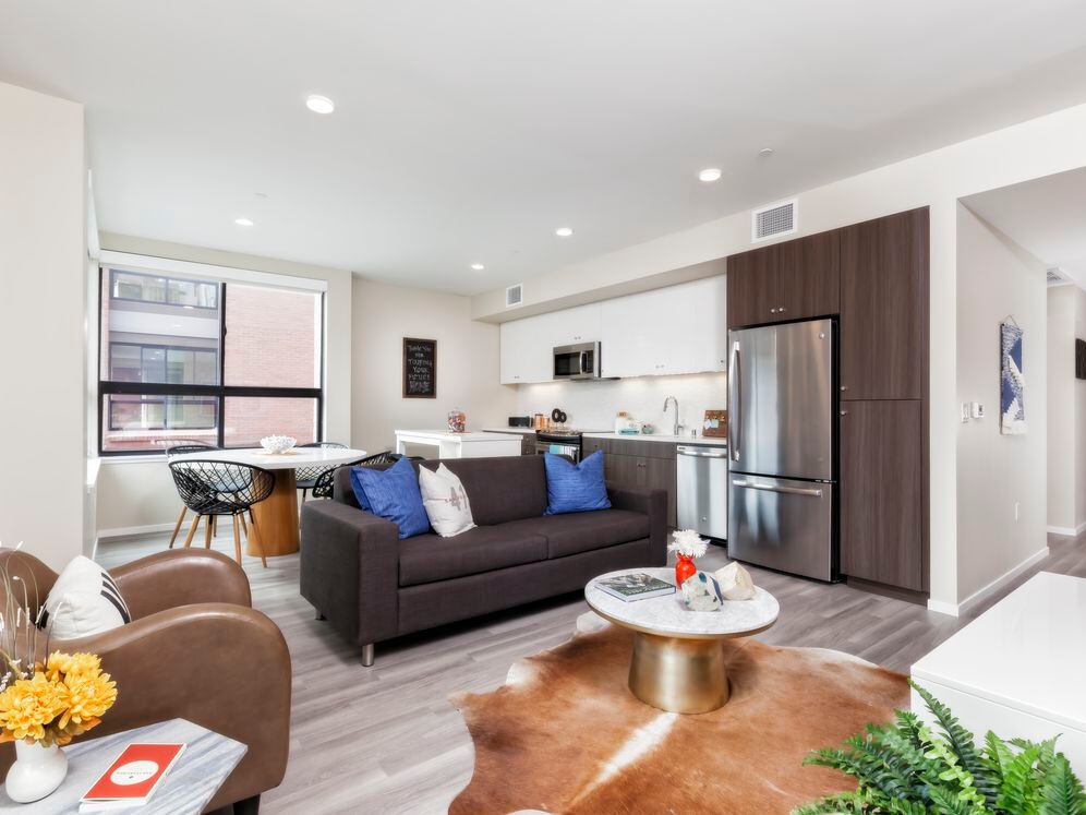 Living and dining area with hard surface flooring and open concept kitchen with stainless steel appliances