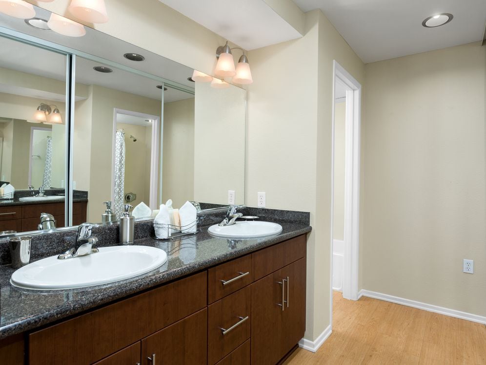 Classic Package I bath with chestnut cabinetry, grey speckled granite countertops, and hard surface flooring