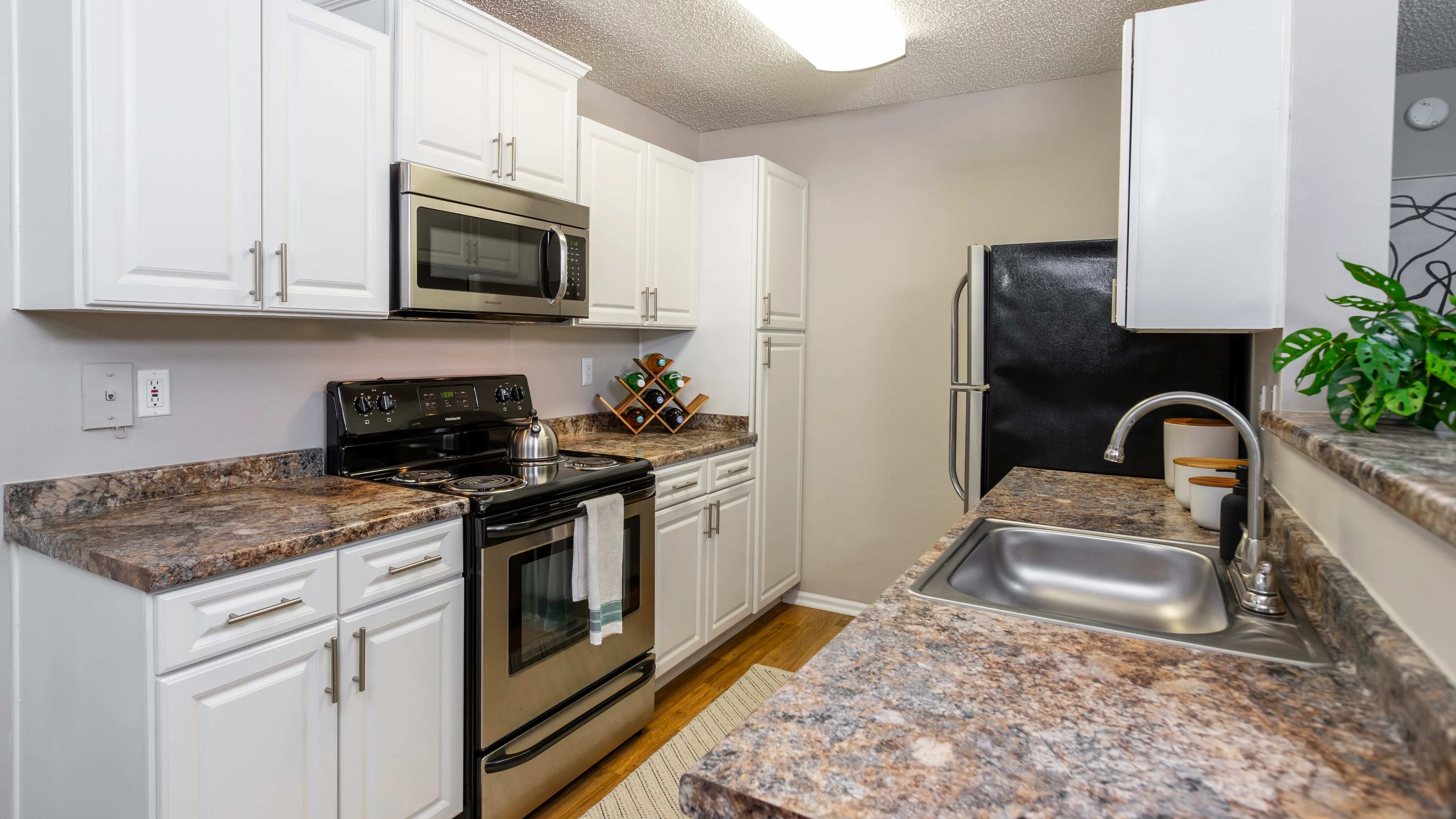 This modern galley-style kitchen features stainless steel appliances, white cabinetry, and expansive countertops—perfect for prepping, cooking, and entertaining.