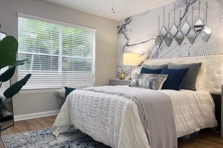 Spacious bedrooms featuring a ceiling fan, walk-in closets, and large windows allowing natural sunlight to shine through.