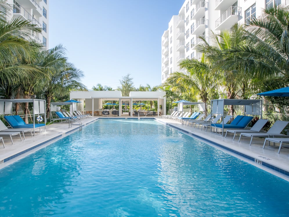 Swimming pool and sundeck with cabanas and lounge seating. Gazebo with flat screen TV.