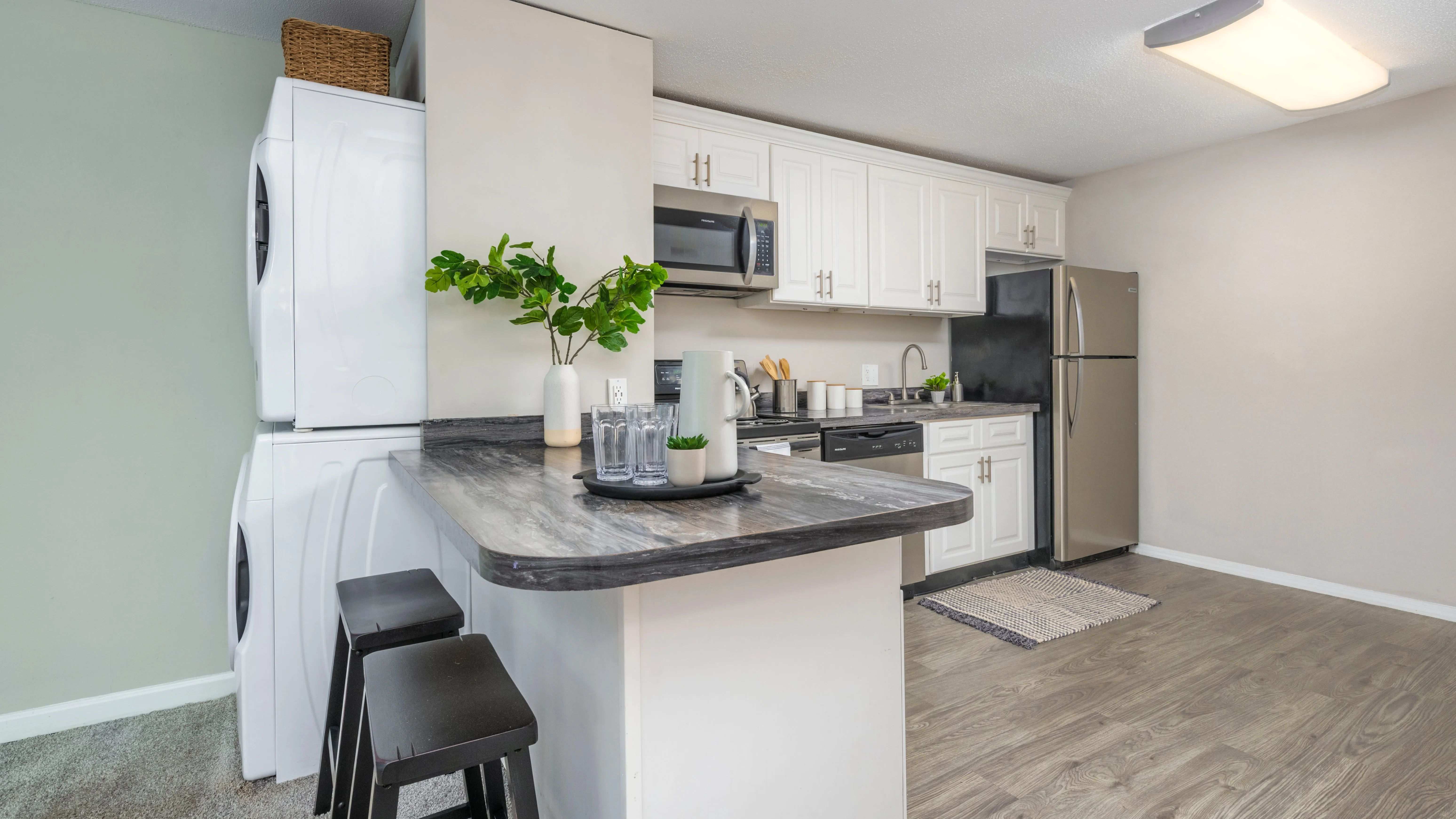 A versatile kitchen with a convenient breakfast bar, perfect for cooking, studying, or folding your laundry. The centrally located full-size washer and dryer is perfectly placed for ultimate convenience.