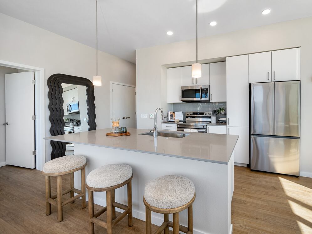 Finish Scheme I kitchen with grey quartz countertops, white cabinetry, grey subway tile backsplash, stainless steel appliances, and hard surface flooring