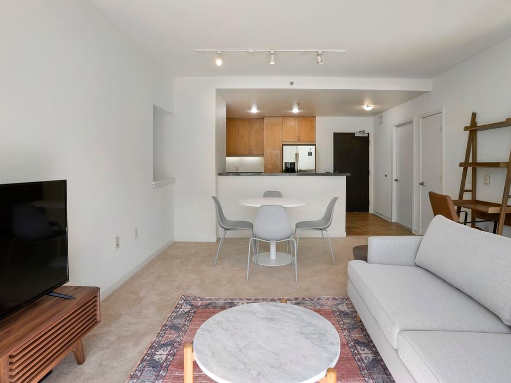 Furnished+ apartment homes come outfitted with a sofa, side chair, side table, coffee table, TV stand and 50" Television (Representative Image – exact items and style of furnishings may vary)