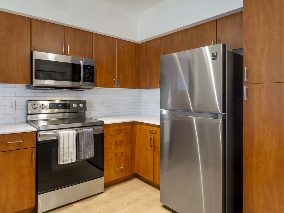 Newly renovated Finish Package II apartment homes feature kitchens with cherry cabinetry, white quartz countertops, stainless steel appliances, upgraded lightning, and hard surface flooring