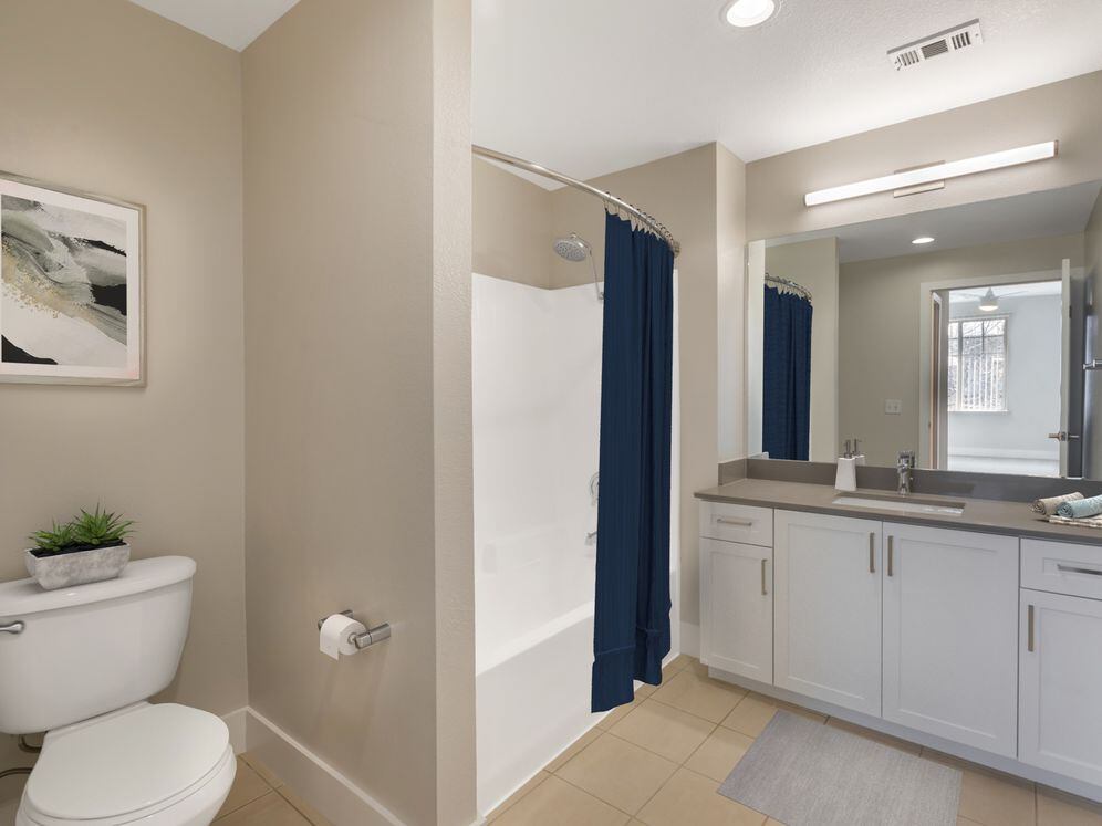 Renovated Package I bath with white cabinetry, grey quartz countertops, and hard surface flooring