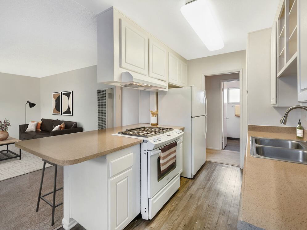 Classic Package I kitchen with white appliances, beige laminate countertops, white cabinetry, and hard surface flooring (select homes)