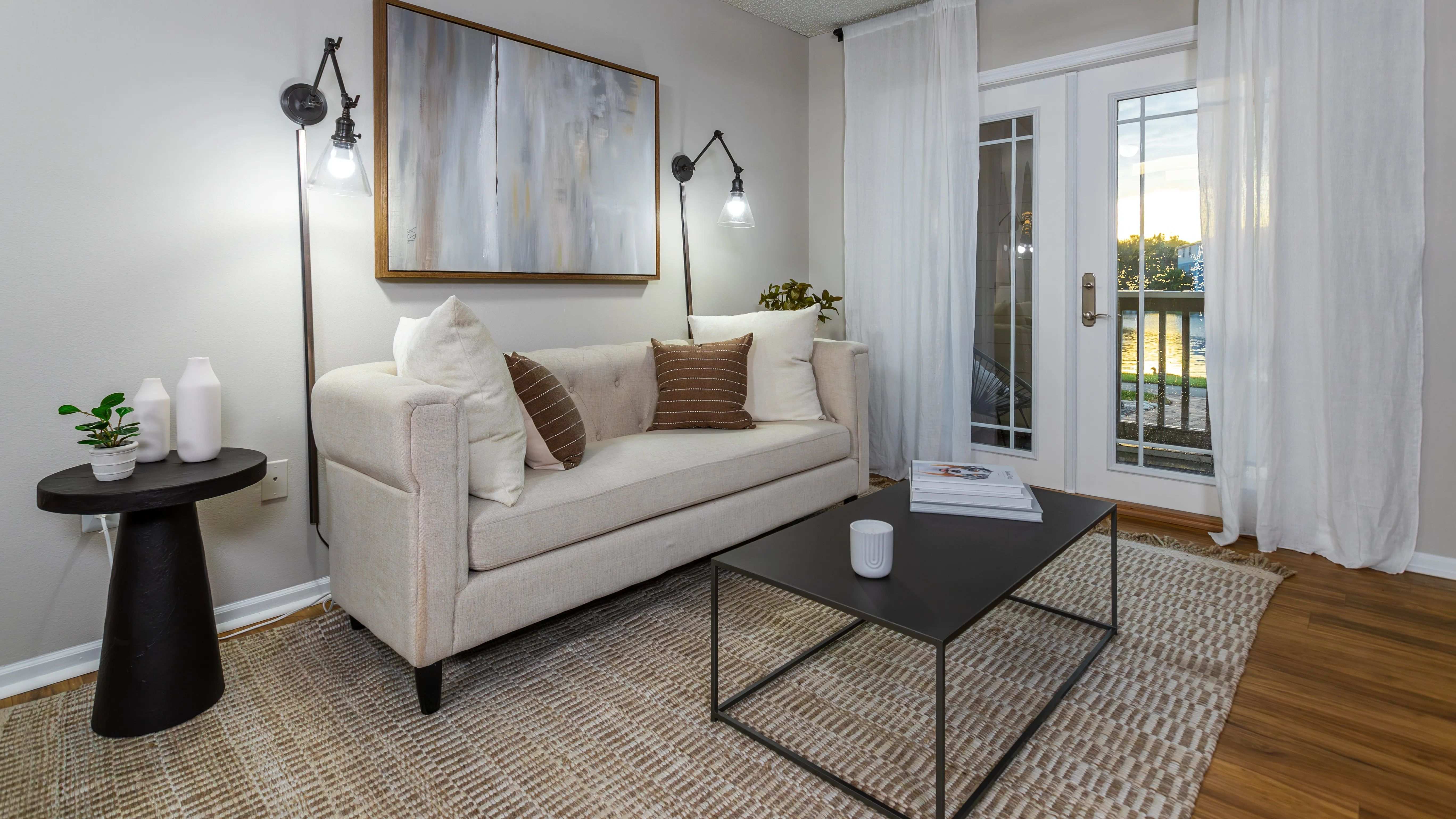 This stylish living room offers a comfortable retreat with modern lighting, and abundant natural light through double glass doors that open to your private patio.