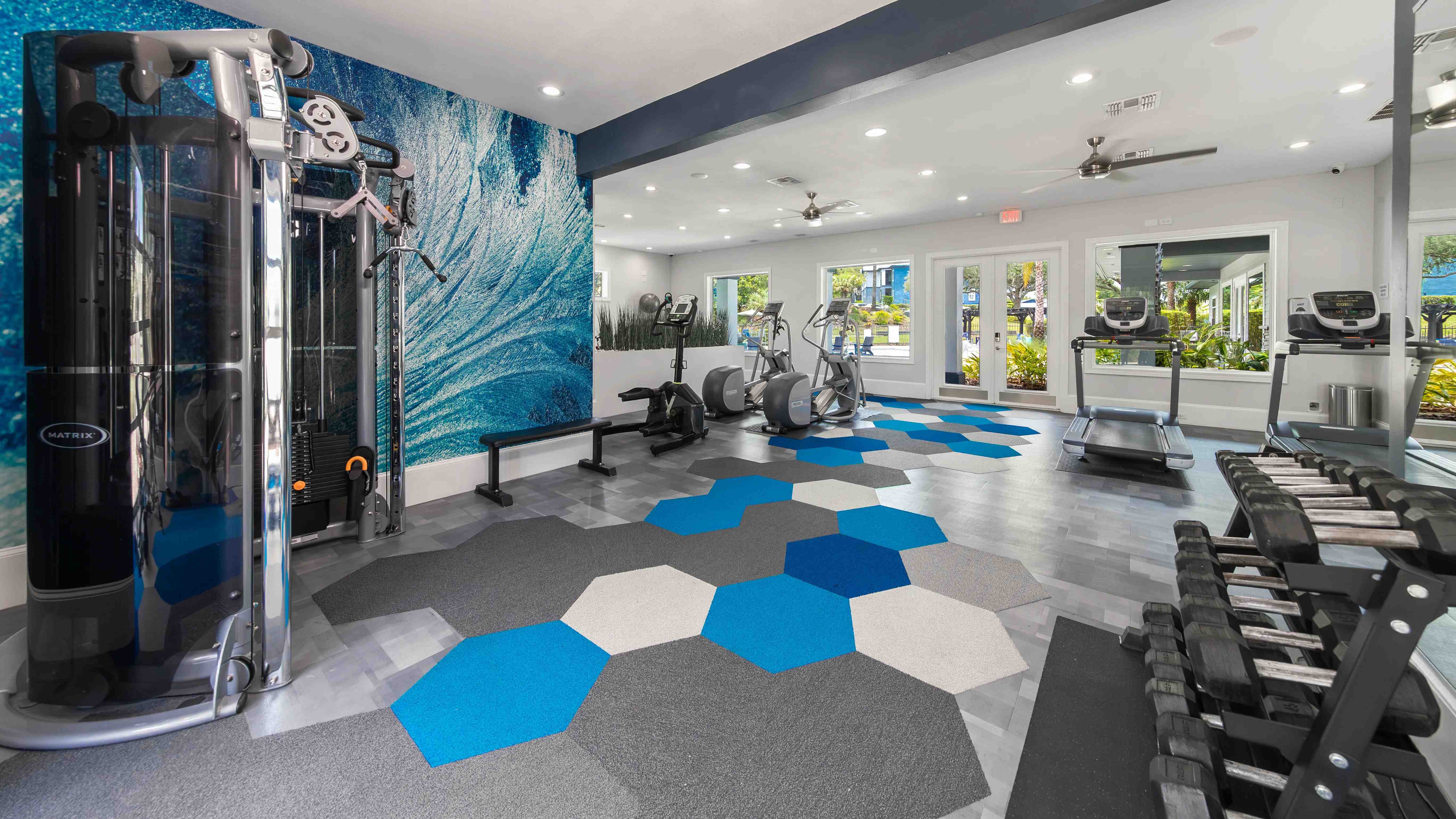 The fitness center at Elevate 155 features premium cardio machines, free weights, and strength equipment in a vibrant, contemporary space.