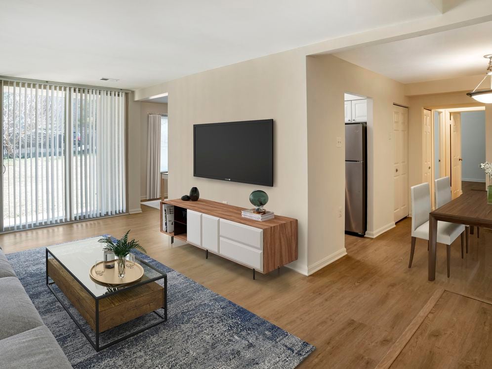 Renovated Package I living room and dining area featuring hard surface flooring in select units
