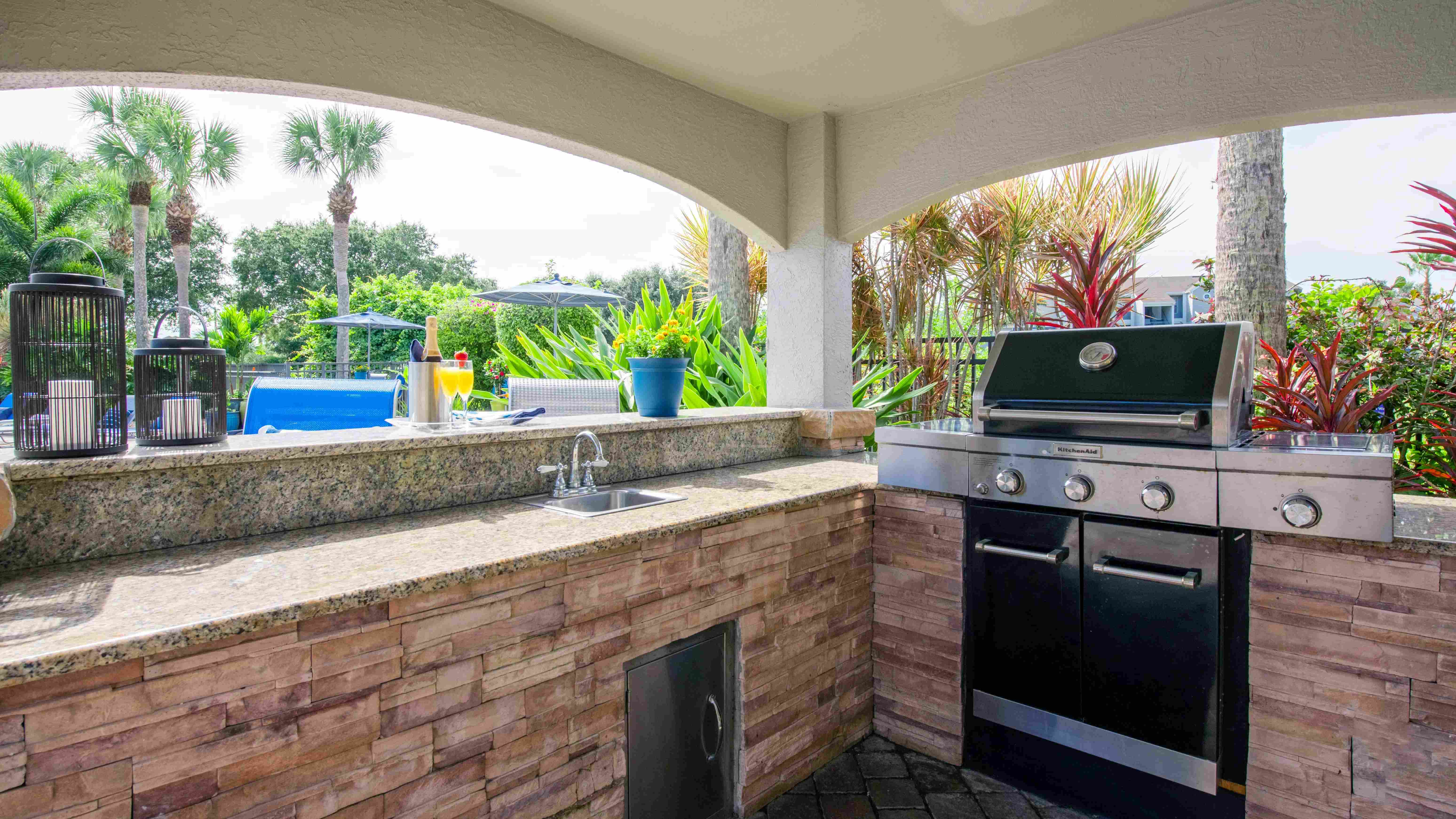 Savor the good life mastering the grill in our shaded outdoor kitchen, complete with a sink, ample counter space, and everything you need to whip up a poolside culinary masterpiece. 