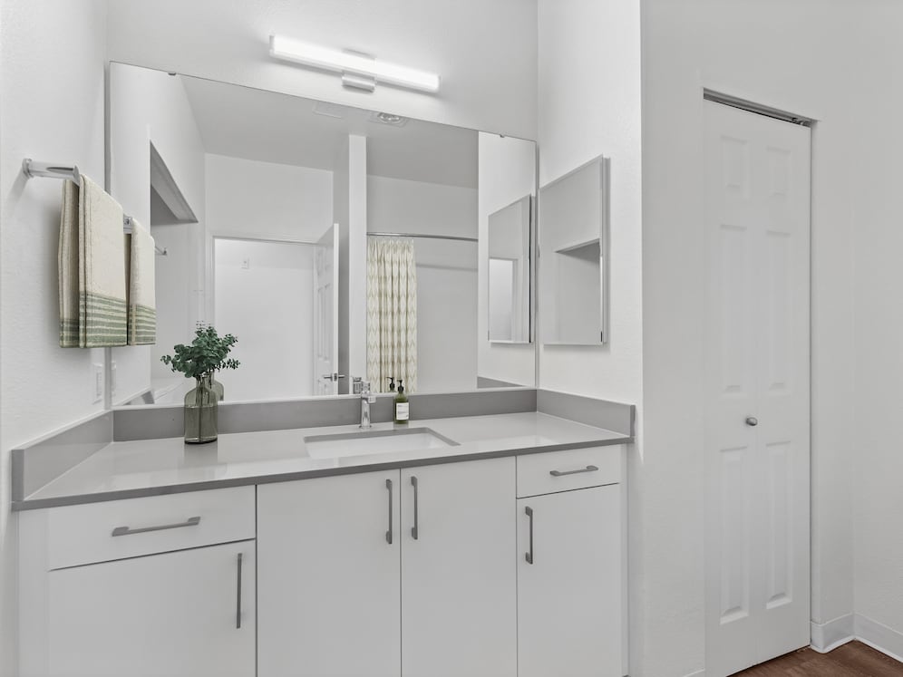 Renovated Package I bath with white cabinetry, grey quartz countertops, and hard surface flooring