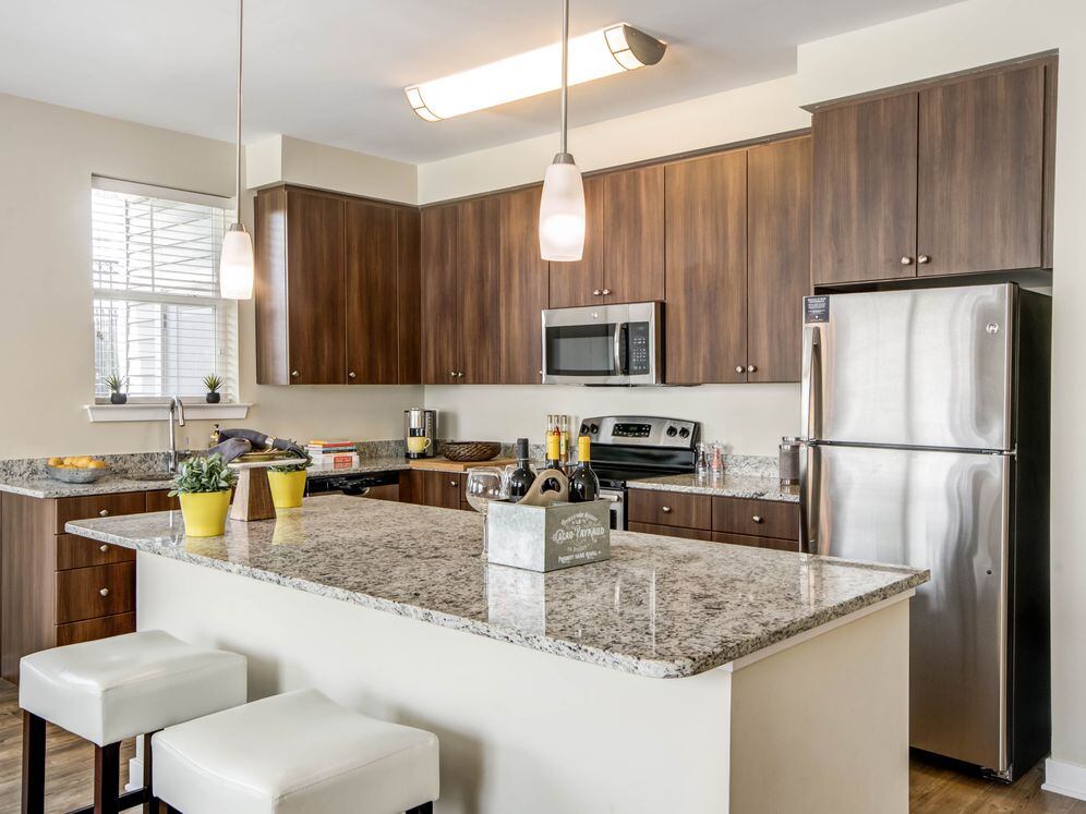 Two bedroom open concept kitchen with granite countertops, stainless-steel appliances, kitchen island and hard surface flooring