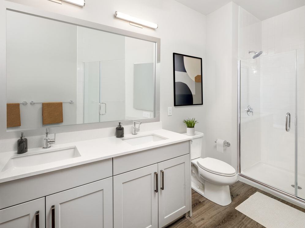 Bath with white quartz countertop, light grey cabinetry, and hard surface flooring