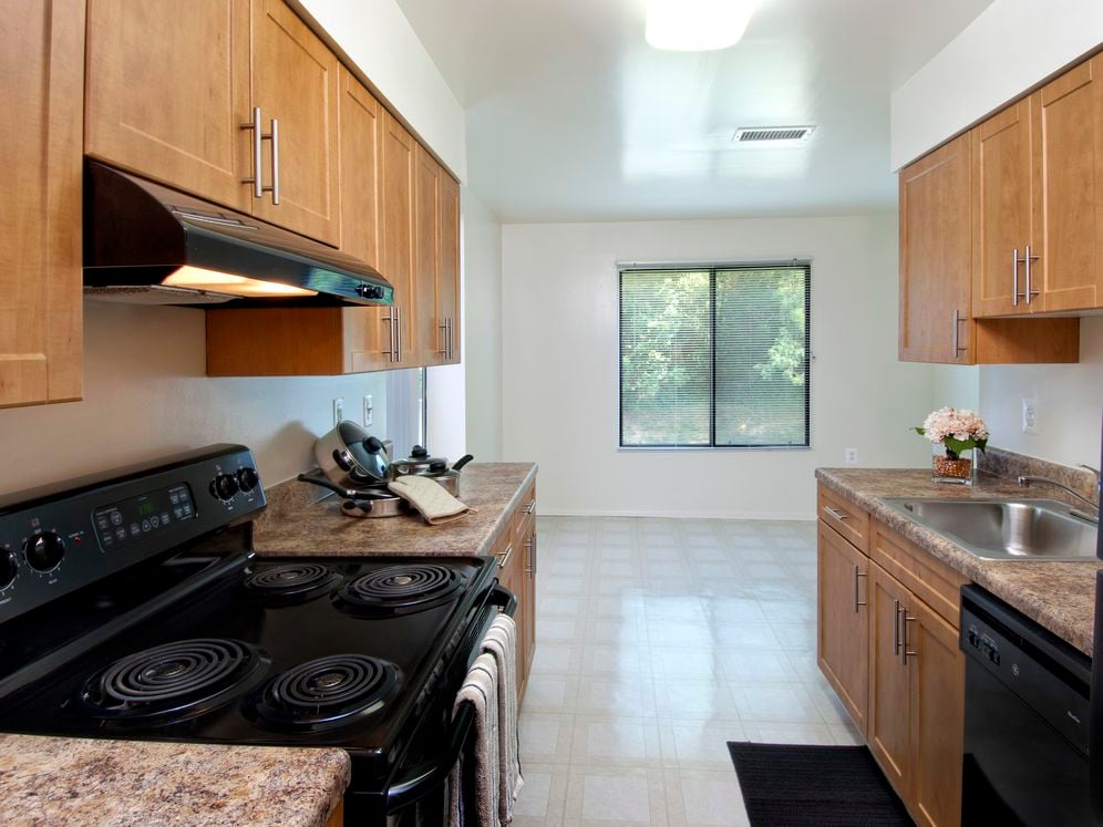 Classic Package kitchen featuring black appliances, oak cabinetry, brown laminate countertops, and tile flooring