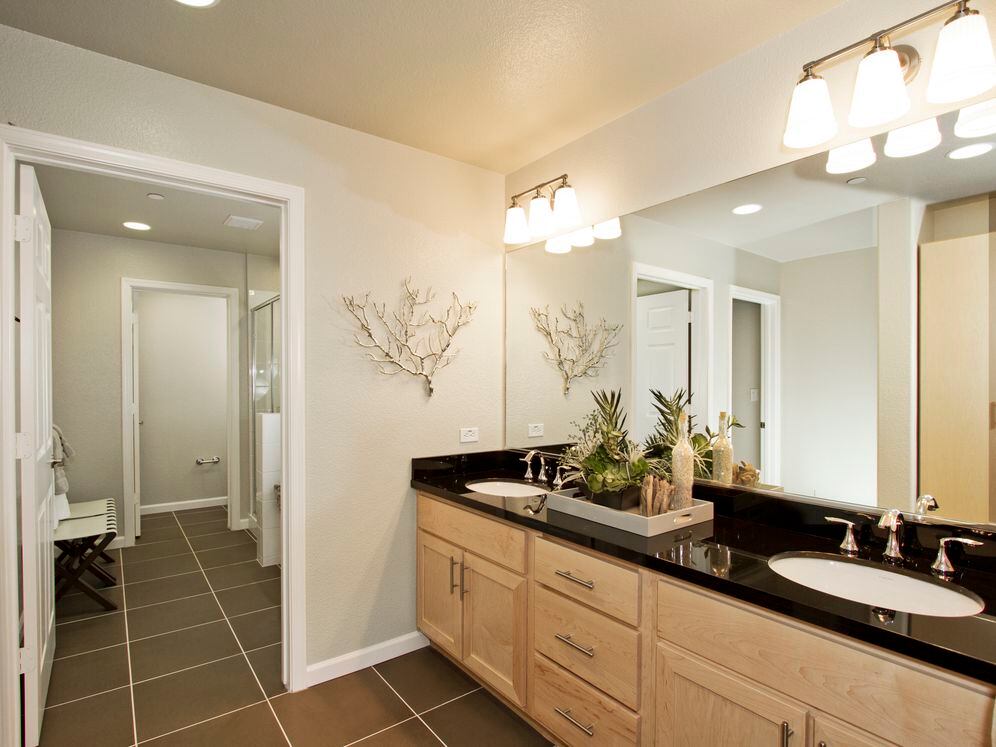 Townhome bath with oak cabinetry and hard surface flooring