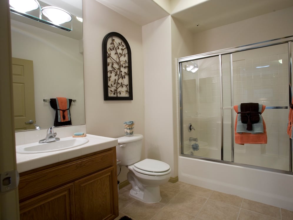 Classic Package I bath with white tile countertop, oak cabinetry, and tile flooring