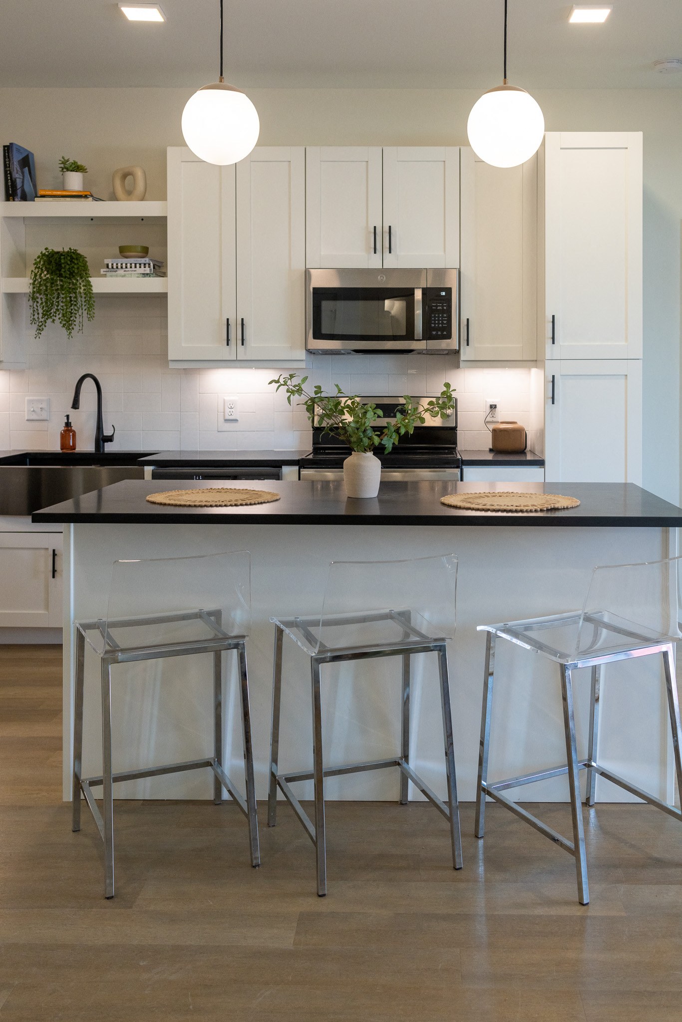 a kitchen with white cabinets and a black counter top