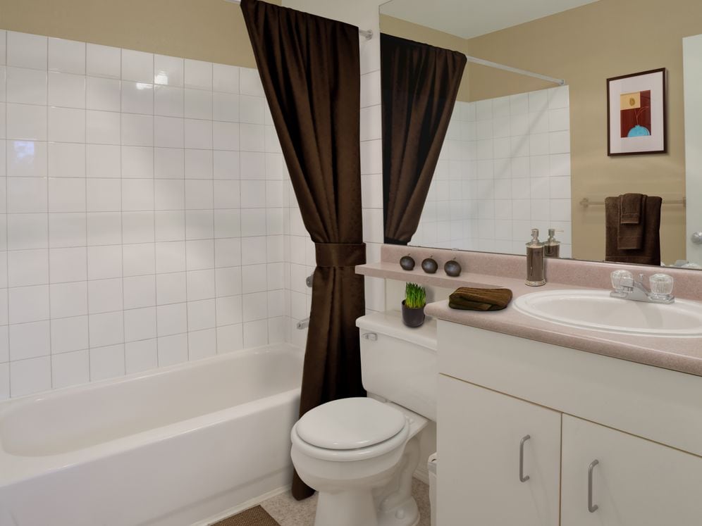 Classic Package I bath with laminate countertops, white cabinetry, and laminate flooring