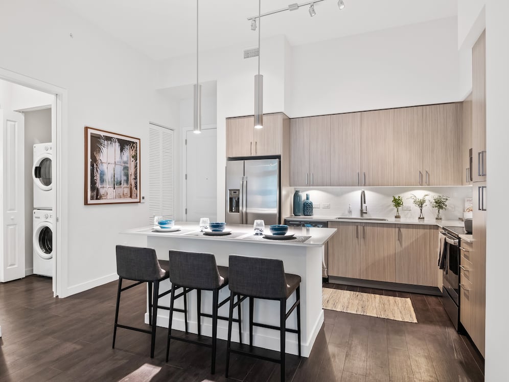 Kitchen with oak cabinetry, undercabinet lighting, white quartz countertops, and hard-surface vinyl plank flooring