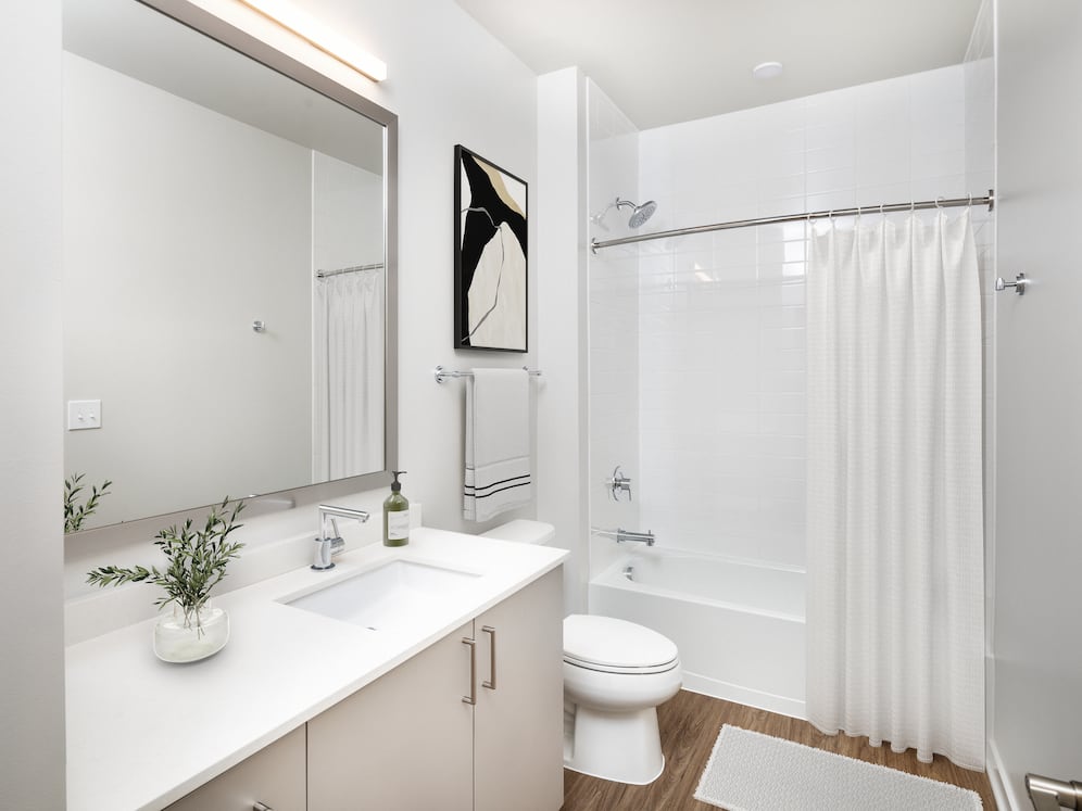 Design Collection II bath with cream quartz countertop, oak cabinetry, and hard surface flooring
