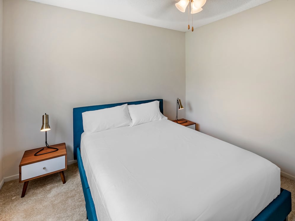 Furnished+ apartment homes feature queen bed with mattress, two pillows, dresser, nightstands, lamp, and mirror. (Representative Image – exact items and style of furnishings may vary)