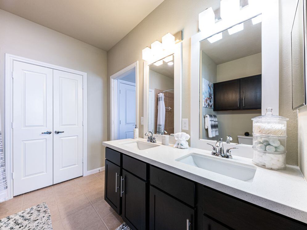 Baths with dark cabinetry, white quartz countertops, and hard surface flooring