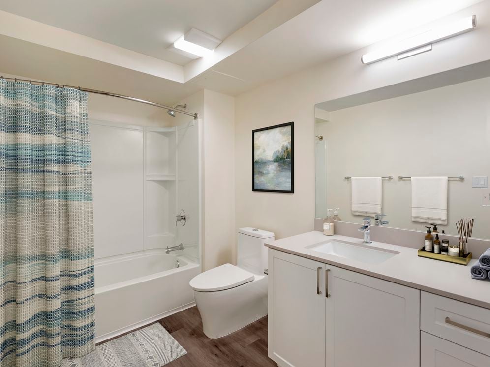 Bath with beige quartz countertops, white cabinetry, and hard surface flooring (Select Home)