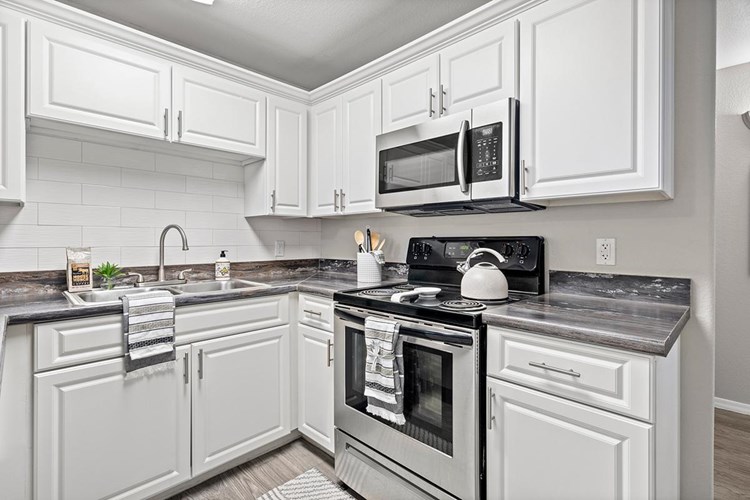 Newly renovated kitchens featuring a large breakfast bar, granite-style counter tops, and ample cabinetry.