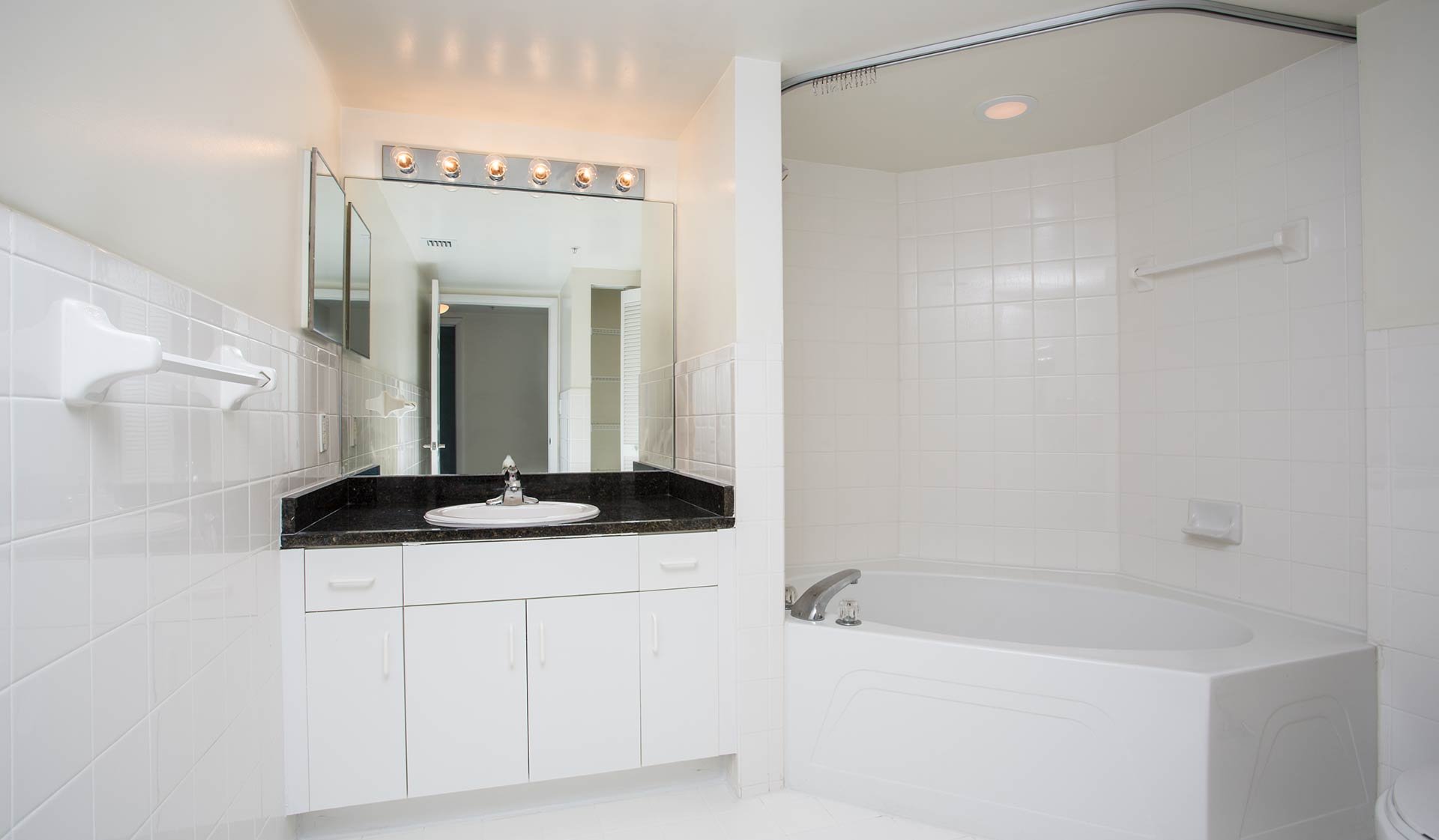 Bathroom features large mirror and neutral tile