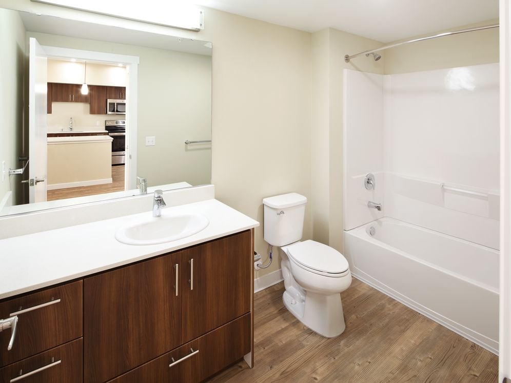 Phase I - Scheme A Kitchen with dark cabinetry, stainless appliances, white quartz countertops, and hard surface flooring