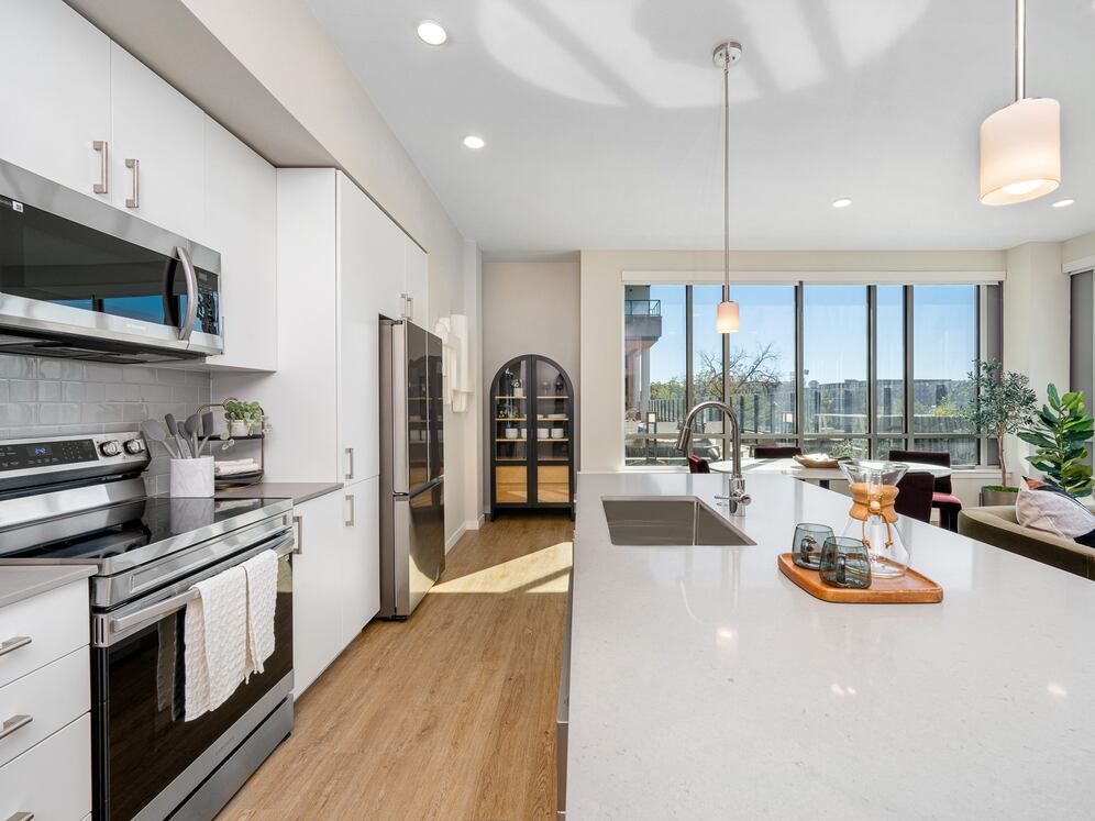 Finish Scheme I kitchen with grey quartz countertops, white cabinetry, grey subway tile backsplash, stainless steel appliances, and hard surface flooring