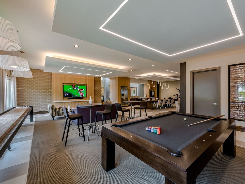 Resident lounge with shuffleboard and billiards, flat screen televisions, entertaining kitchen and seating