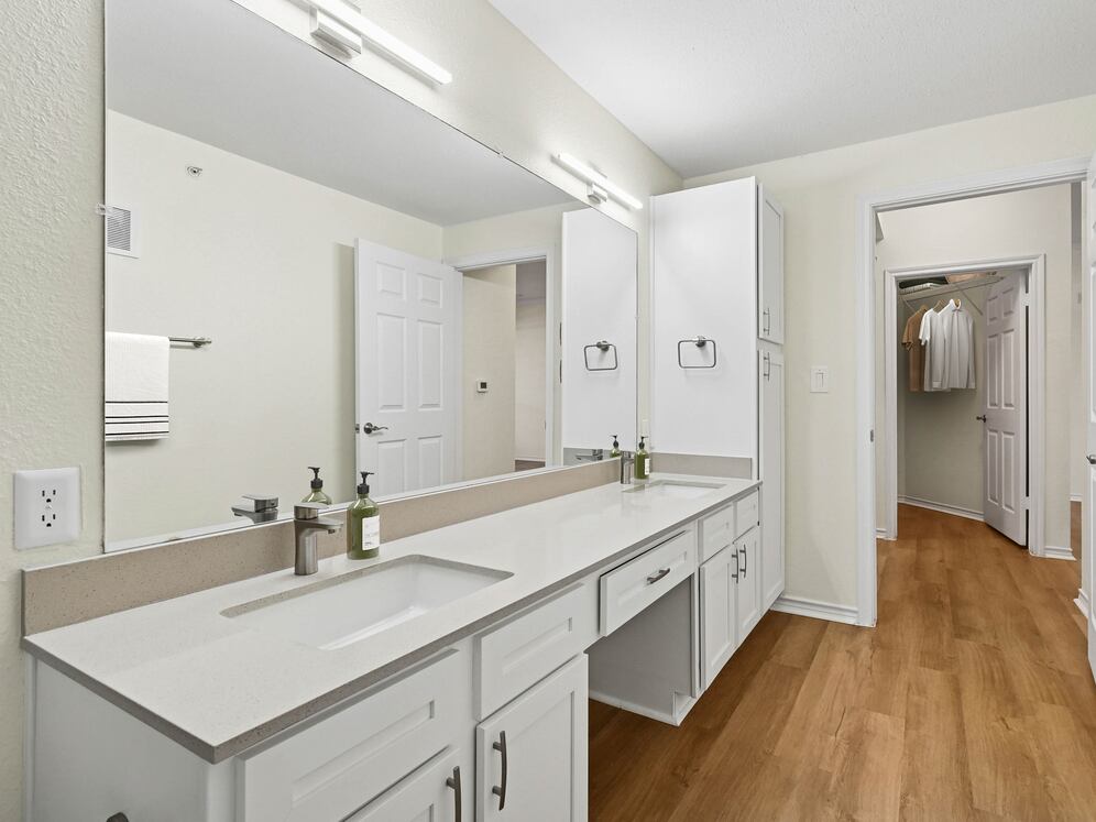 Renovated Package I bath with grey quartz countertop, white cabinetry, and hard surface flooring