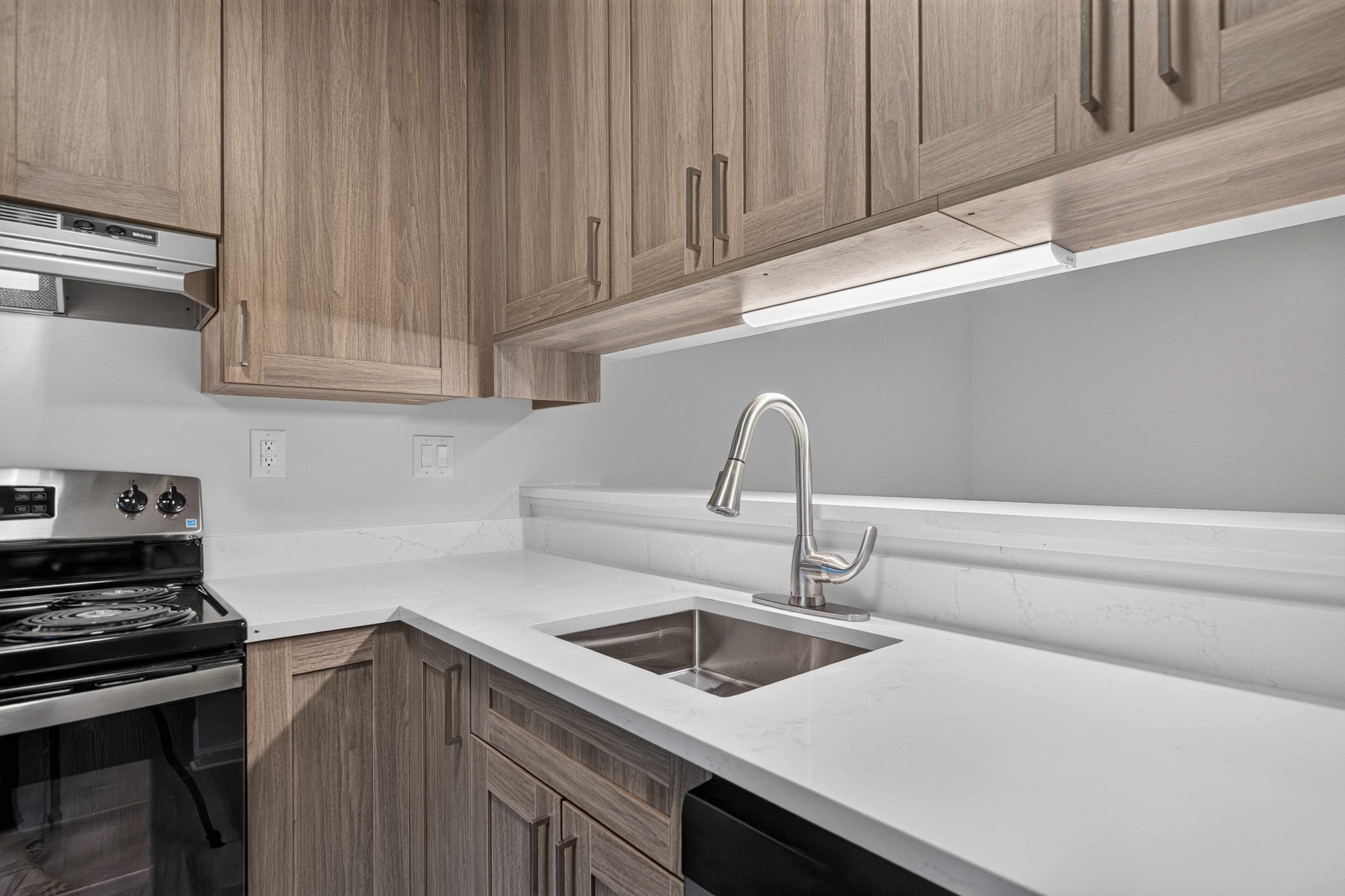 Modern kitchen with under cabinet lighting at Park Lane Apartments in Southfield, MI.