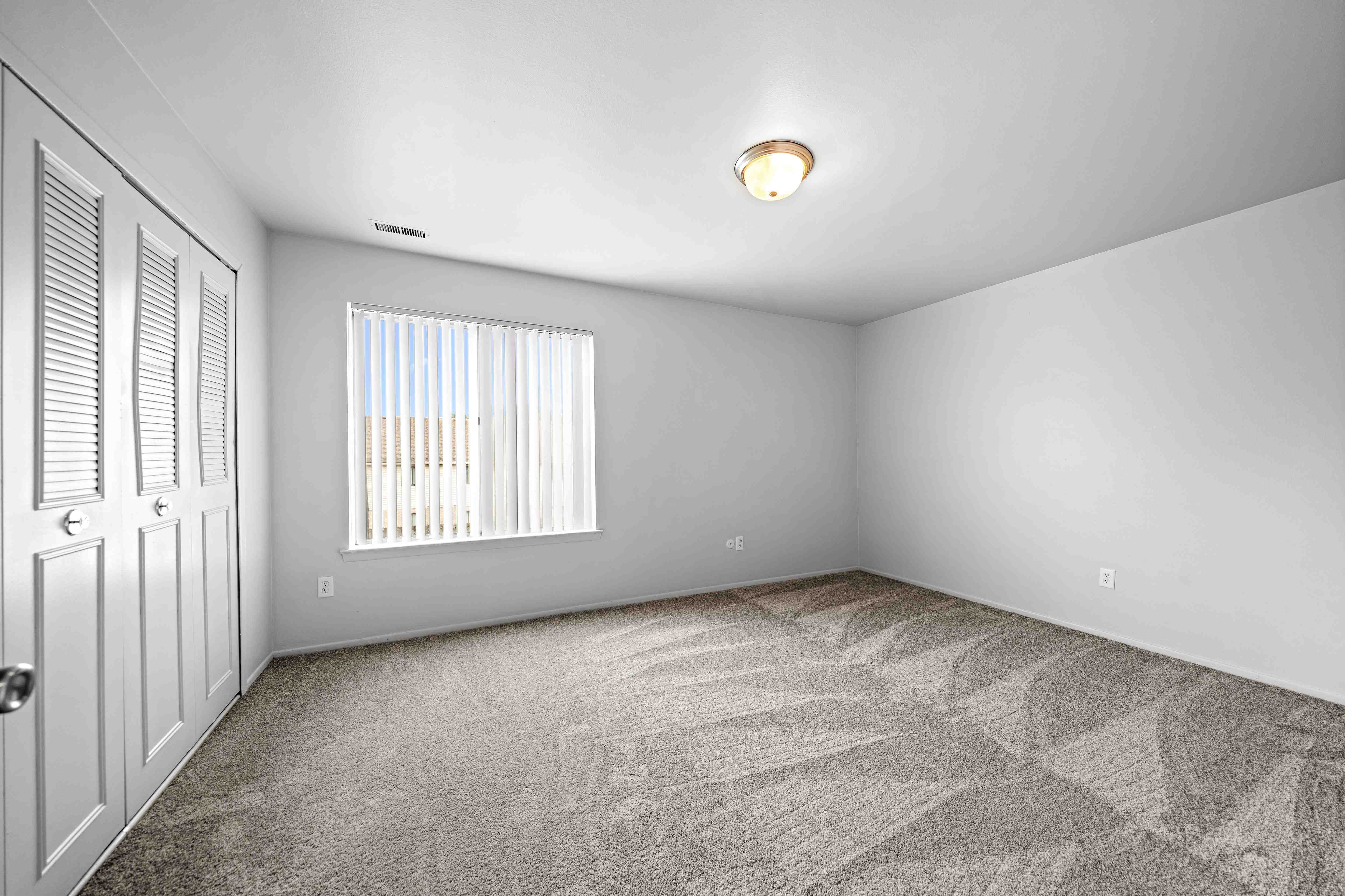 Spacious bedroom with ample storage space at Knottingham Apartments in Clinton Township, MI.