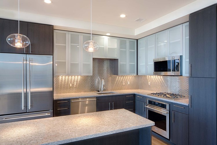 Penthouse kitchens feature frosted-glass cabinet doors, quartz countertops and breakfast bars