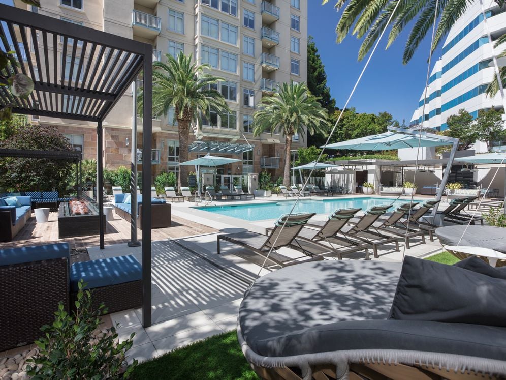 Swimming Pool and Sundeck with Cabanas Lounge Seating and Hanging Chairs