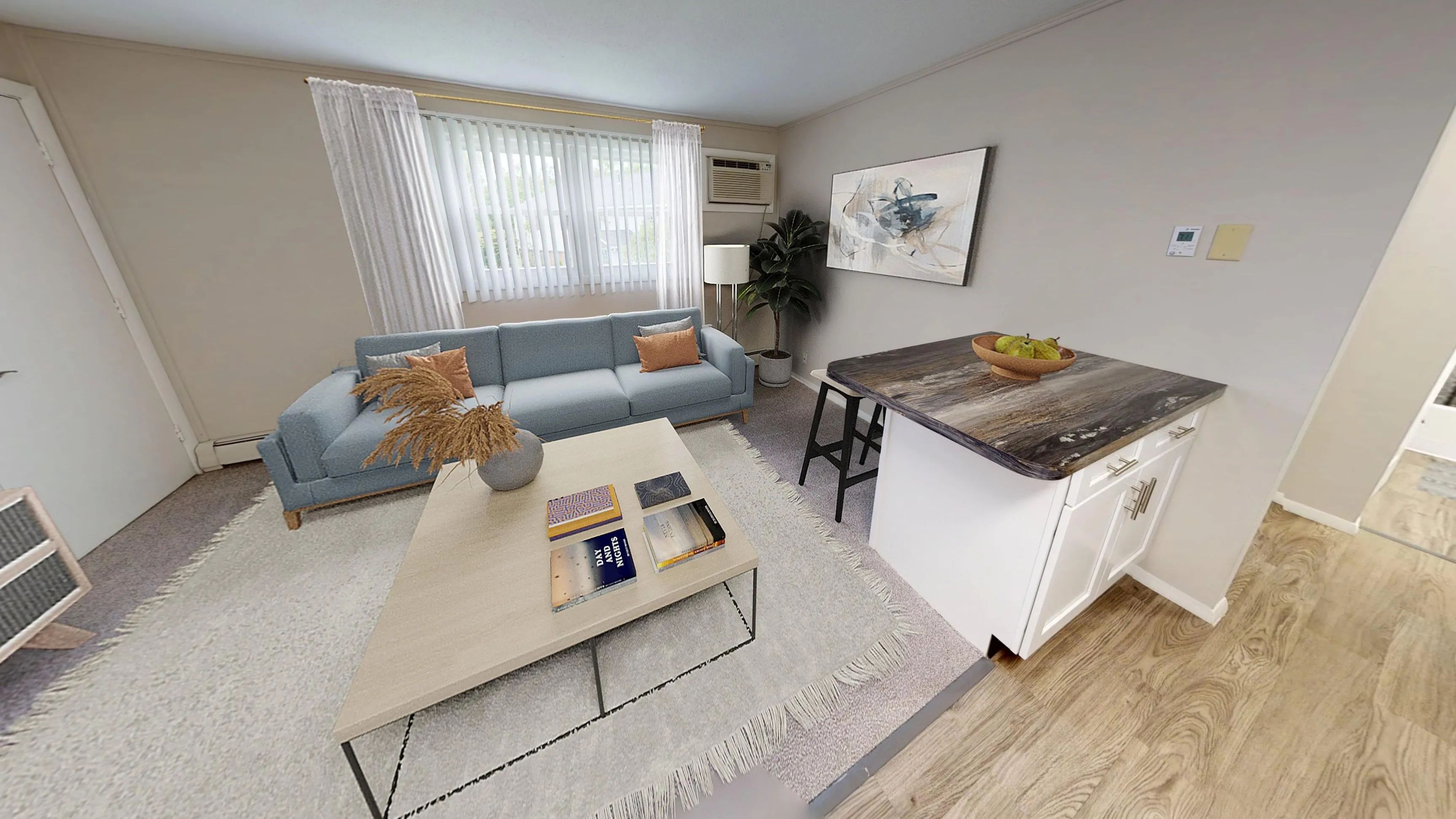 Enjoy a cozy and modern living room in The Dickenson 1-bedroom floor plan at Aspen Chase Apartments, complete with a breakfast bar, plush carpeting, and abundant natural light.