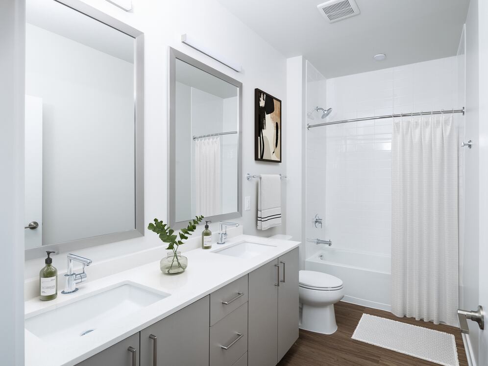 Design Collection II bath with cream quartz countertop, oak cabinetry, and hard surface flooring