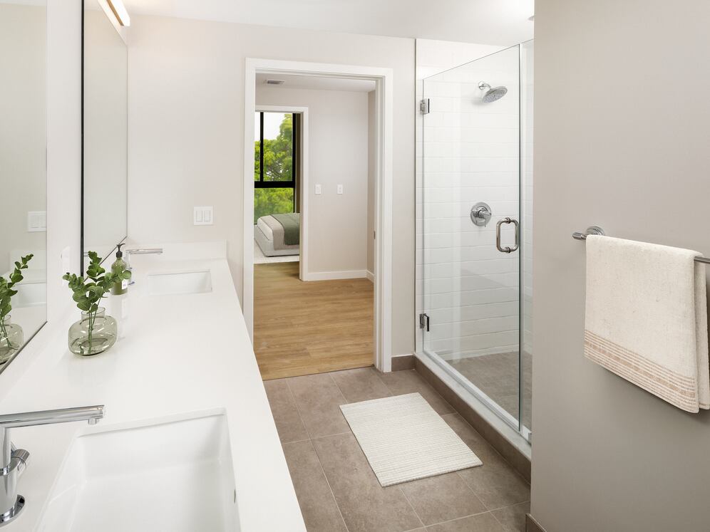 Upgrade Collection II Three-bedroom primary bath with double-sink vanity, white quartz countertops, and standing shower