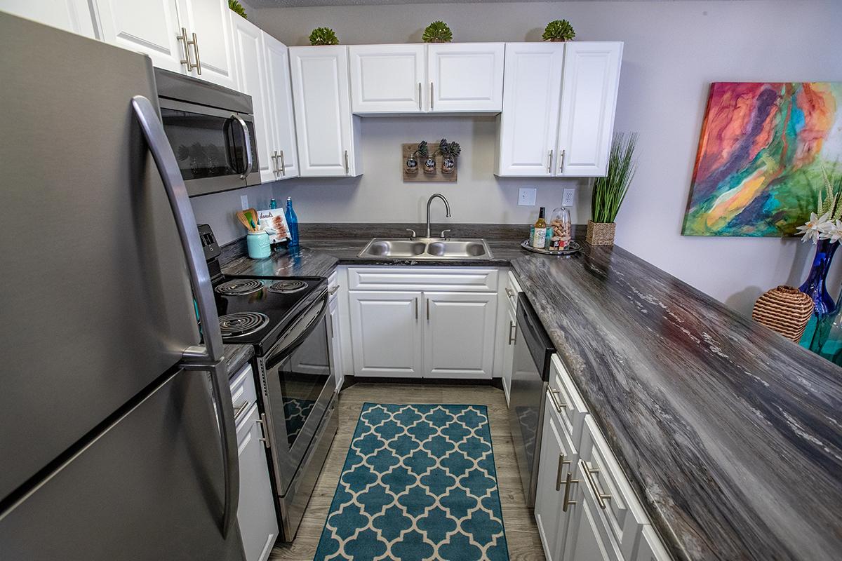 Large kitchens featuring above range microwaves, granite-style counter tops, and an ample amount of cabinets.